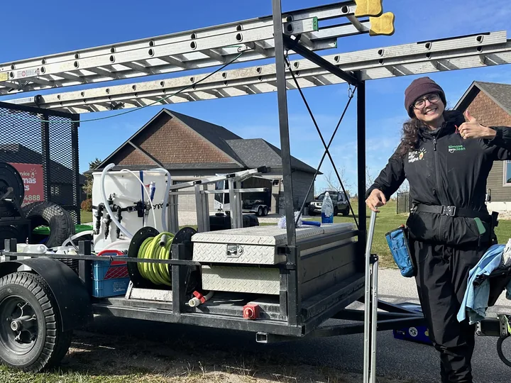 A Nord technician beside the trailer-mounted pure-water system — ladders racked overhead, hose reels and filtration tanks aboard